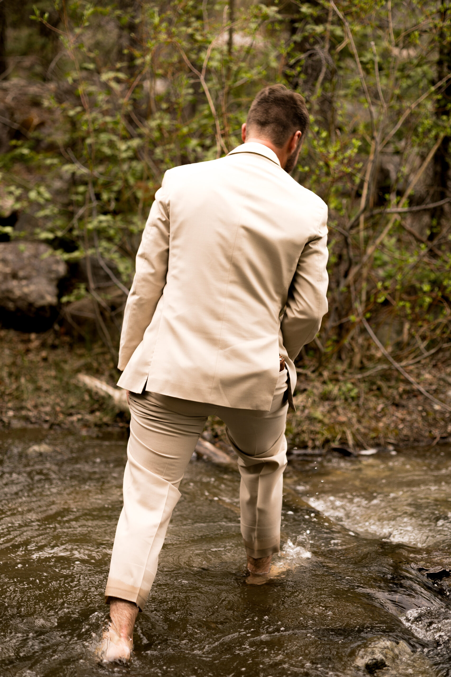 Groom crossing creek elopement