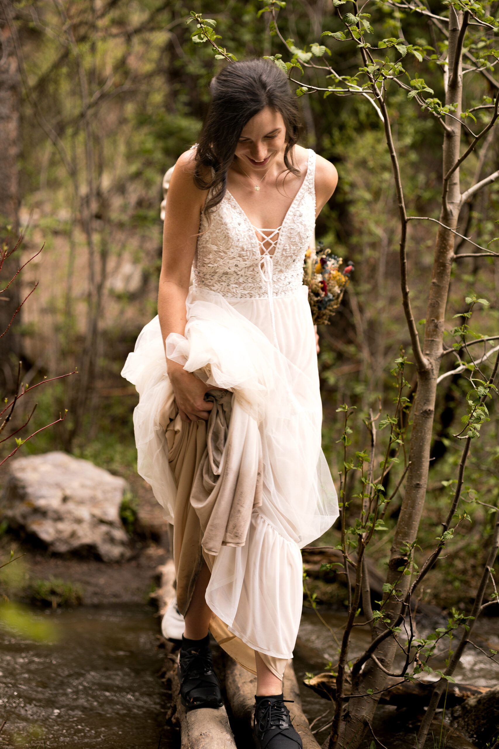 bride crossing creek elopement photos
